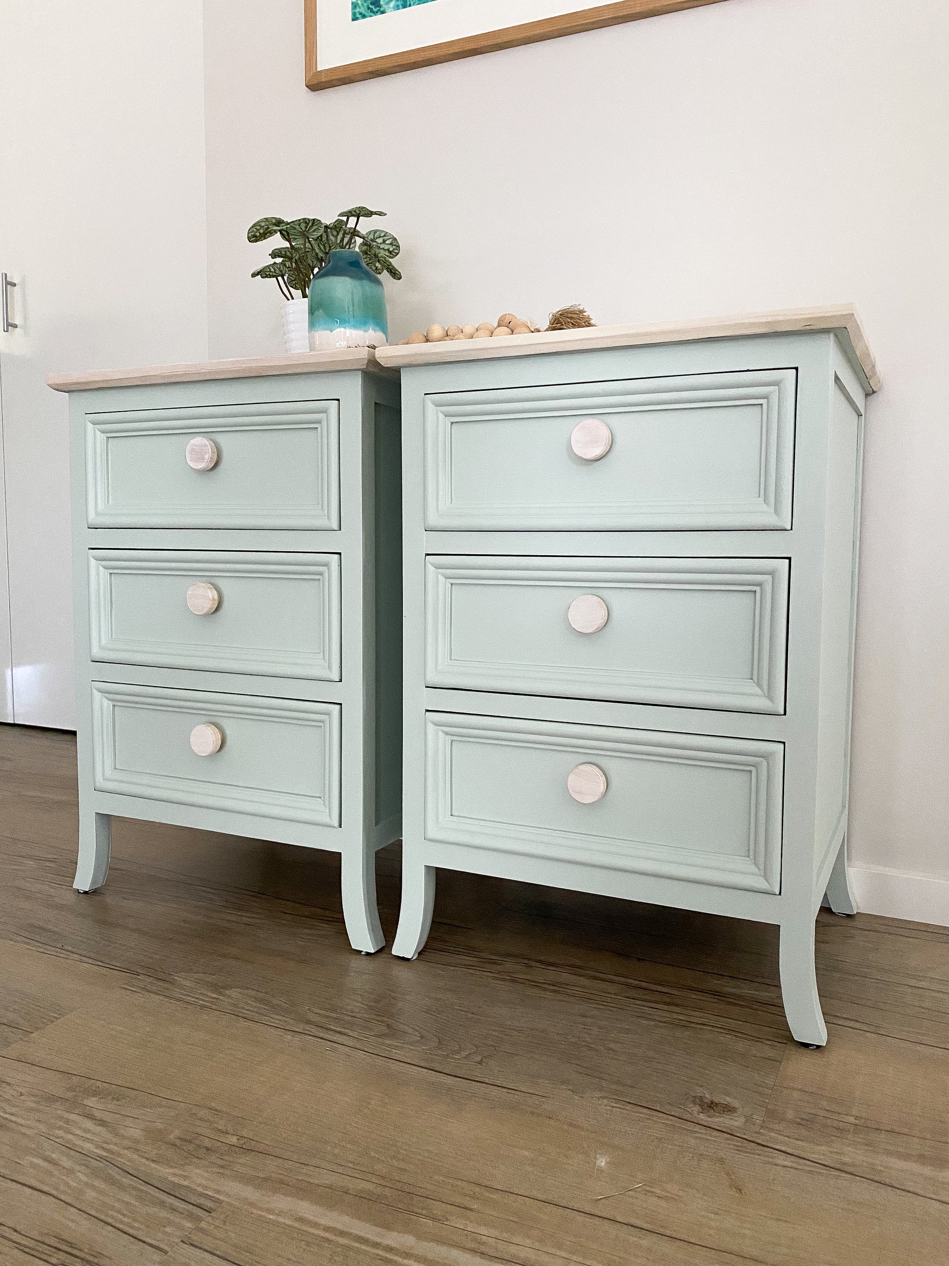 soft green painted bedside tables  in coastal style with round wooden drawer knobs