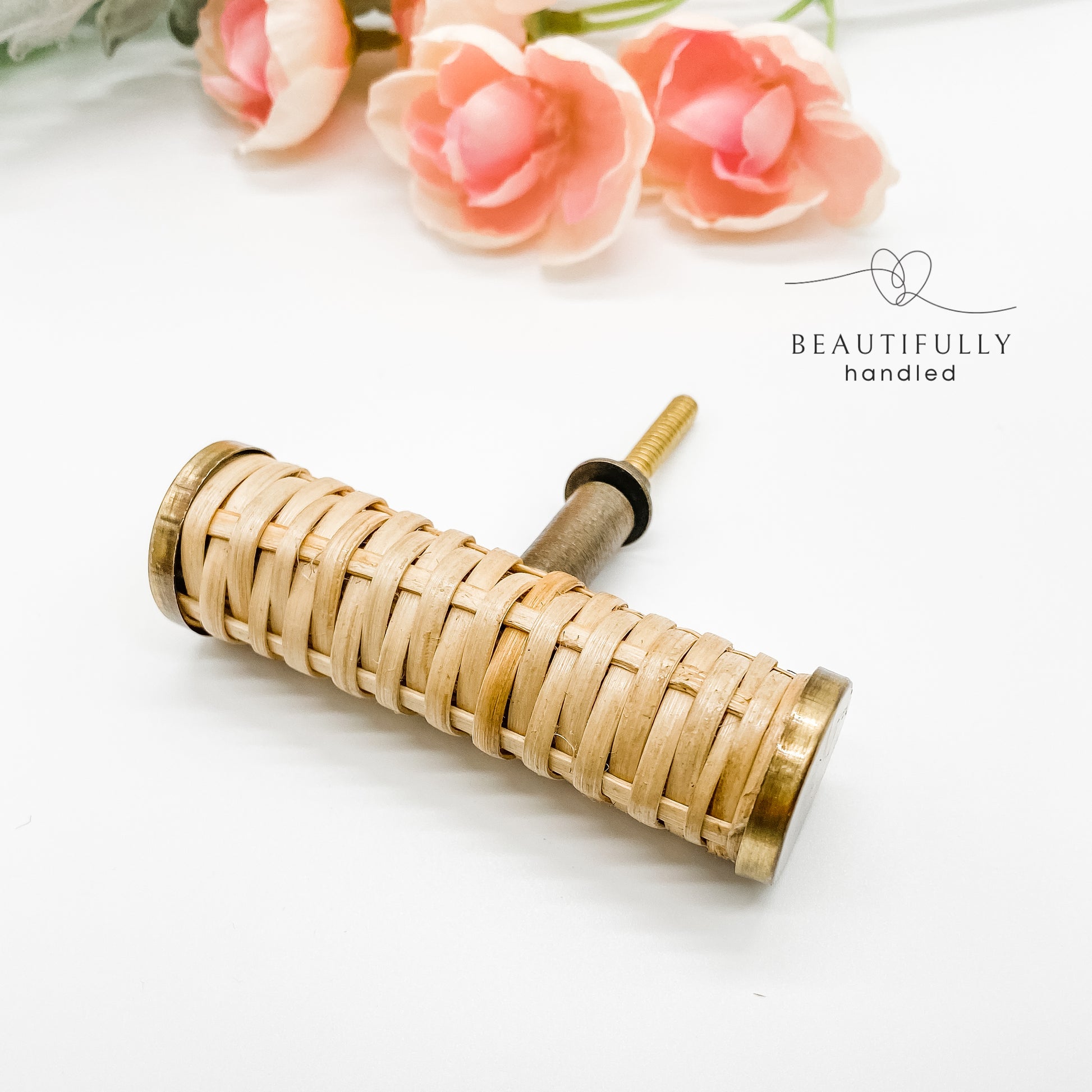 rattan woven drawer handle t bar with brass edges and brass bolt on white background