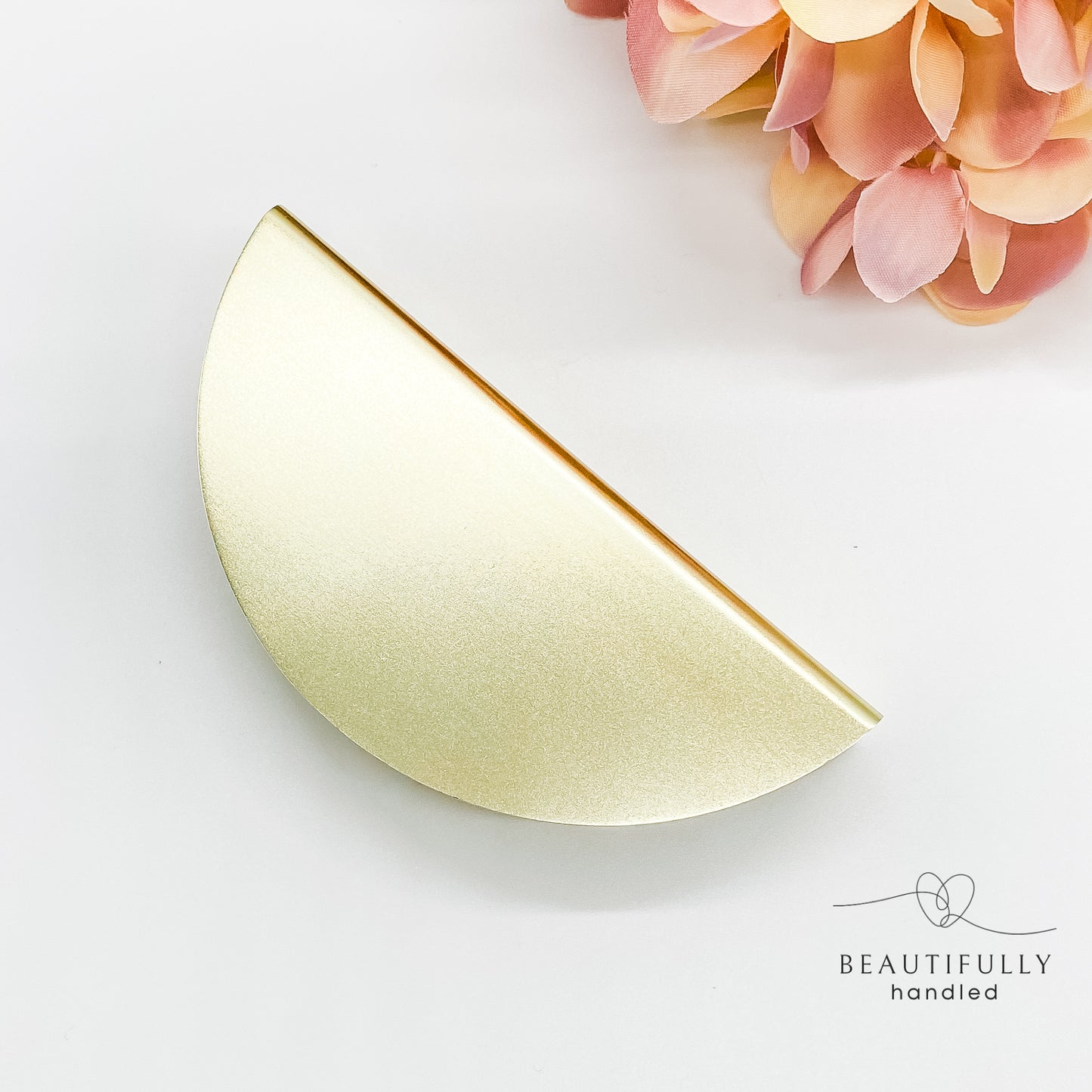 gold half moon drawer handle on plain white background