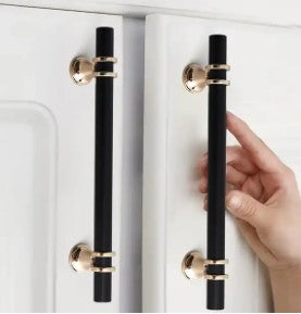 black and gold drawer handles on white kitchen doors with hand touching handles