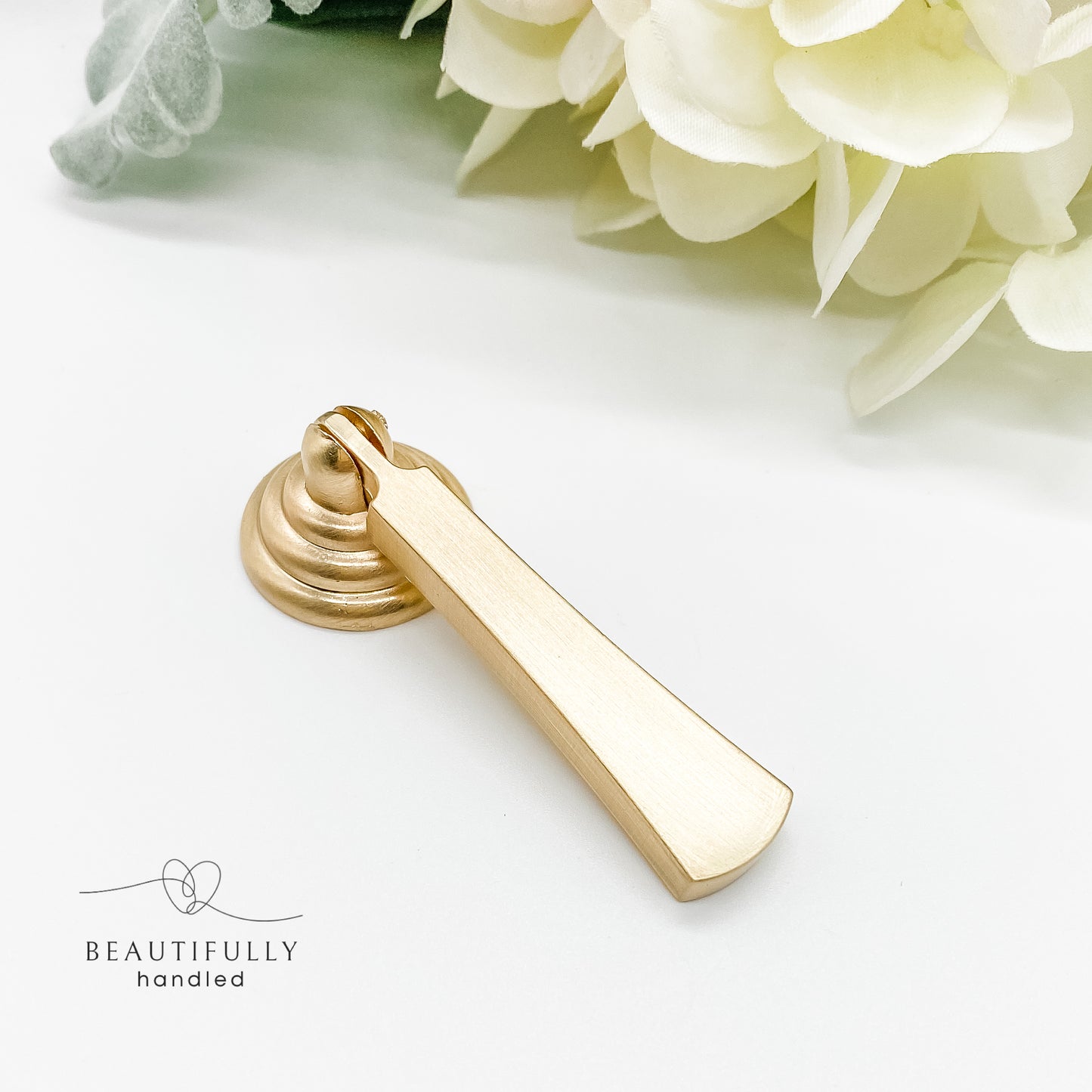 gold drawer handle with drop pull in brushed gold on white background